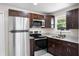 Modern kitchen featuring stainless steel appliances, granite countertops, and dark wood cabinetry at 720 N 6Th St, Haines City, FL 33844