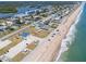 Stunning aerial view showcasing the expansive beach, oceanfront properties, and neighborhood at 865 Ladyfish Ave # C104, New Smyrna Beach, FL 32169
