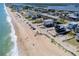 A picturesque beach with soft sand, gentle waves, and charming beach houses along the coastline at 865 Ladyfish Ave # C104, New Smyrna Beach, FL 32169