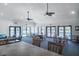 A well-lit clubhouse interior with tables, chairs, ceiling fans, and sliding glass doors to the pool area at 865 Ladyfish Ave # C104, New Smyrna Beach, FL 32169