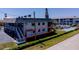 Exterior view of home, including access to shuffle board and community pool at 865 Ladyfish Ave # C104, New Smyrna Beach, FL 32169