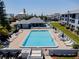 A swimming pool in a community setting, with comfortable lounge chairs, well-maintained landscaping and a nearby clubhouse at 865 Ladyfish Ave # C104, New Smyrna Beach, FL 32169