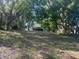 Lush backyard featuring mature trees, offering a serene and shaded environment, with a house in the background at 91 N Triplet Lake Dr, Casselberry, FL 32707