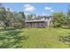 Exterior view of home with a spacious backyard, deck, and lush landscaping at 9222 Charles E Limpus Rd, Orlando, FL 32836