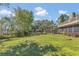 Spacious backyard with lush lawn and mature trees, offering serene outdoor living at 9222 Charles E Limpus Rd, Orlando, FL 32836