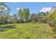 Expansive backyard featuring lush greenery, trees, and views of the lake at 9222 Charles E Limpus Rd, Orlando, FL 32836