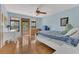 Comfortable bedroom with light blue walls, hardwood floors, ceiling fan, and a door to the outside balcony at 9222 Charles E Limpus Rd, Orlando, FL 32836