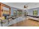 Cozy bedroom featuring a fireplace, hardwood floors, ceiling fan, and a door to the outside balcony at 9222 Charles E Limpus Rd, Orlando, FL 32836