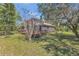 Beautiful exterior showcasing a large wooden deck and screened porch overlooking a well-manicured yard at 9222 Charles E Limpus Rd, Orlando, FL 32836