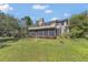 Exterior showcasing expansive decks and a screened porch with lush landscaping in the background at 9222 Charles E Limpus Rd, Orlando, FL 32836