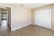 Bright bedroom featuring wood-look flooring, white closet doors, and neutral paint at 10665 Whitman Cir, Orlando, FL 32821