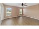 A bedroom featuring wood-look flooring, neutral colored walls, a ceiling fan, and a window with a view at 10665 Whitman Cir, Orlando, FL 32821