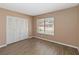 A bedroom featuring wood-look flooring, neutral colored walls, a window with a view, and a closet at 10665 Whitman Cir, Orlando, FL 32821