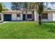 Charming single-story home featuring a well-manicured lawn and a lovely, mature palm tree at 10665 Whitman Cir, Orlando, FL 32821