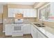 A kitchen featuring white cabinetry, granite countertops, stainless steel appliances, and wood-look flooring at 10665 Whitman Cir, Orlando, FL 32821