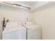 Convenient laundry area featuring a washer and dryer with shelves for storage at 10665 Whitman Cir, Orlando, FL 32821