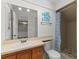Updated bathroom featuring wood cabinets, a large mirror, and shower-tub combo with a blue floral shower curtain at 1152 Grove St, Maitland, FL 32751