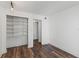 White bedroom features hardwood floors, closet shelving, and an adjacent closet with a full length door at 1152 Grove St, Maitland, FL 32751