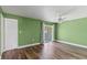 Expansive bedroom features green walls, wood floors, ceiling fan, and closet with bi-fold doors at 1152 Grove St, Maitland, FL 32751