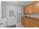 Utility room with wood cabinets, a whiteboard, washer and dryer hookups, and access to the outdoors at 1152 Grove St, Maitland, FL 32751