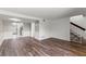 View of the living room featuring wood-look flooring and staircase, leading to a kitchen area at 1152 Grove St, Maitland, FL 32751
