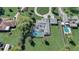 Aerial view of backyard featuring screened pool, lush landscaping, and driveway at 1155 Collins Ave, Orange City, FL 32763