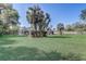 Lush backyard featuring a screened-in enclosure surrounded by mature trees and a well-maintained lawn at 1155 Collins Ave, Orange City, FL 32763