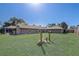 Large, fenced-in backyard showcasing the home's exterior, offering privacy and ample green space for recreation at 1155 Collins Ave, Orange City, FL 32763