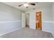 A bright bedroom features neutral walls and carpet, and a view into an adjacent room with a contrasting door at 1155 Collins Ave, Orange City, FL 32763