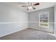 A clean bedroom features neutral walls, carpet, and a window providing ample natural light at 1155 Collins Ave, Orange City, FL 32763