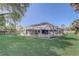 Screened-in pool enclosure in a spacious backyard with a meticulously maintained lawn at 1155 Collins Ave, Orange City, FL 32763