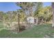 Backyard chicken coop setup with fenced enclosure and small building among tall trees at 1155 Collins Ave, Orange City, FL 32763