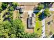 Aerial view reveals the backyard with greenery, a detached garage, and a neatly kept lawn at 117 Orange Ridge Dr, Longwood, FL 32779
