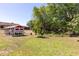 Spacious backyard featuring a charming red and white chicken coop, mature trees, and lush green grass at 117 Orange Ridge Dr, Longwood, FL 32779