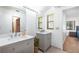 Bright bathroom featuring double sink vanity and view of an adjacent bedroom through an open doorway at 117 Orange Ridge Dr, Longwood, FL 32779