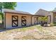 Exterior view of the outbuilding with barn doors and decorative plants on a bright and sunny day at 117 Orange Ridge Dr, Longwood, FL 32779
