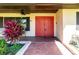 Close-up of the red double doors with modern design details, complemented by a well-maintained garden at 117 Orange Ridge Dr, Longwood, FL 32779