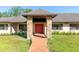 Inviting front entrance with a brick walkway and red double doors, framed by brick pillars and manicured landscaping at 117 Orange Ridge Dr, Longwood, FL 32779