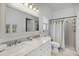 Bright bathroom features a double vanity with marble countertop and a separate shower at 15532 Kensington Trl, Clermont, FL 34711
