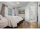 Bedroom showcasing wood flooring, white bedding, and an open doorway to the bathroom at 15532 Kensington Trl, Clermont, FL 34711
