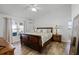 Bedroom boasts wood floors, a ceiling fan, and a view to an outdoor patio at 15532 Kensington Trl, Clermont, FL 34711