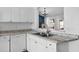 Well-lit kitchen featuring modern countertops, an undermount sink, and white cabinets at 15532 Kensington Trl, Clermont, FL 34711