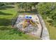 A fenced playground features a sandbox, slides, and other play equipment at 15532 Kensington Trl, Clermont, FL 34711