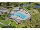 A large community pool is surrounded by lounge chairs and landscaping near a pond at 15532 Kensington Trl, Clermont, FL 34711