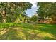 Lush green backyard with mature trees, offering a serene and private outdoor space at 1555 Waterwitch Dr, Orlando, FL 32806