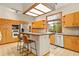 Well-lit kitchen with a breakfast bar, wood cabinets, stainless steel appliances, and a window overlooking the backyard at 1555 Waterwitch Dr, Orlando, FL 32806
