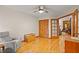 Living room with hardwood floors, a ceiling fan, storage and seating, and glass paneled doors at 1555 Waterwitch Dr, Orlando, FL 32806