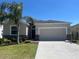 Charming single-Gathering home featuring a well-manicured lawn and a two-car garage at 1711 Penrith Loop, Orlando, FL 32824