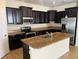 Modern kitchen with stainless steel appliances, granite countertops, and a center island at 1711 Penrith Loop, Orlando, FL 32824