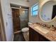 Well-lit bathroom featuring granite countertops, a modern sink, and a glass-enclosed shower at 1720 Hope Dr, Ormond Beach, FL 32174